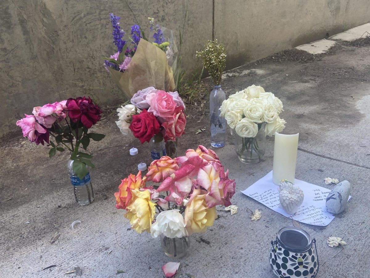 Flowers, candles and notes left at memorial site outside of parking structure on April 22. 